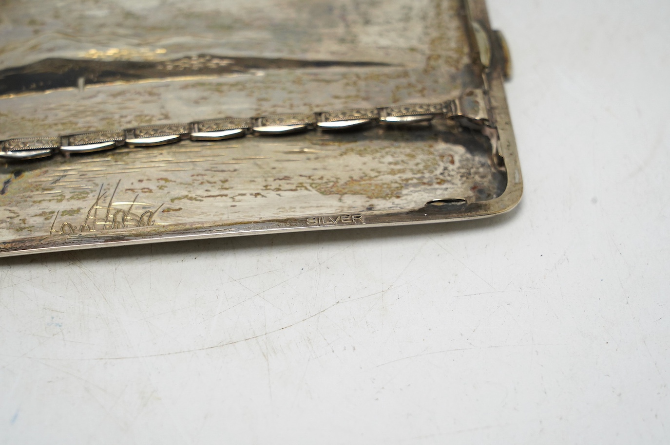 A white metal (stamped) and dark patinated Japanese silver cigarette case, decorated with a view of Mount Fuji, signed, 11cm, gross weight 113 grams. Condition - fair